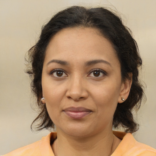 Joyful latino adult female with medium  brown hair and brown eyes