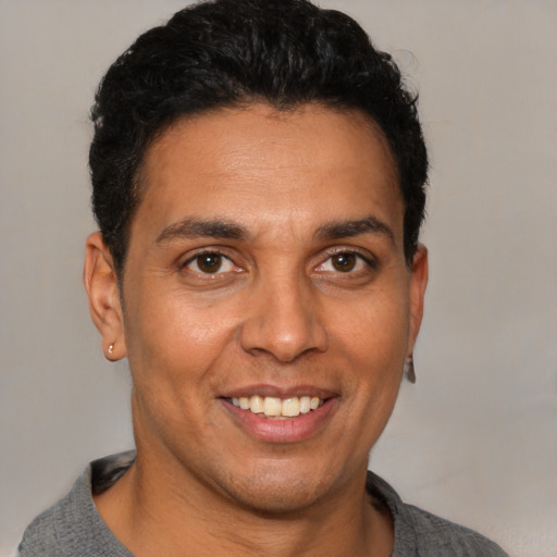Joyful latino adult male with short  black hair and brown eyes