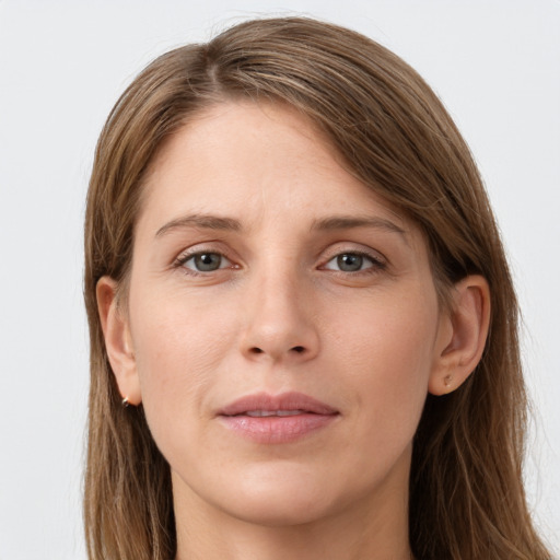 Joyful white young-adult female with long  brown hair and grey eyes