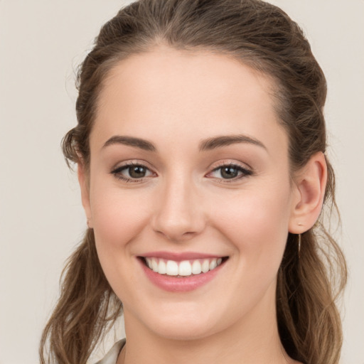 Joyful white young-adult female with long  brown hair and grey eyes