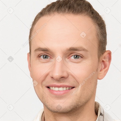 Joyful white young-adult male with short  brown hair and grey eyes