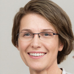 Joyful white adult female with medium  brown hair and blue eyes