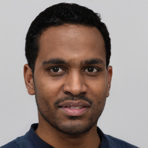 Joyful black young-adult male with short  black hair and brown eyes