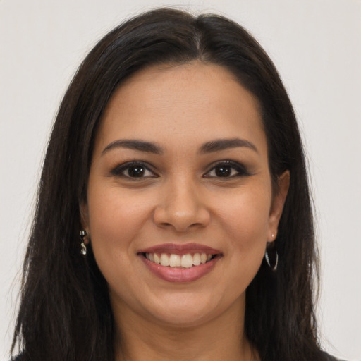 Joyful latino young-adult female with long  brown hair and brown eyes