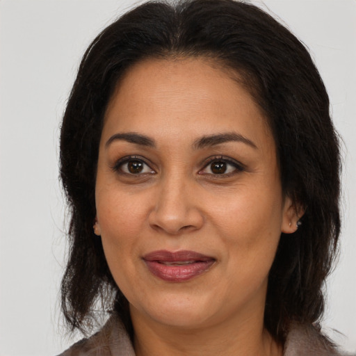 Joyful latino adult female with medium  brown hair and brown eyes