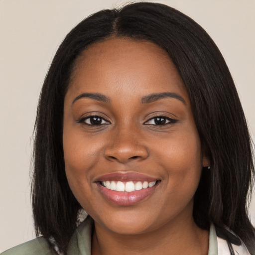 Joyful black young-adult female with long  brown hair and brown eyes