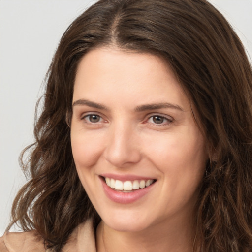 Joyful white young-adult female with long  brown hair and brown eyes