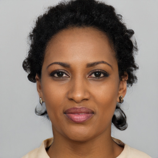 Joyful black young-adult female with short  black hair and brown eyes