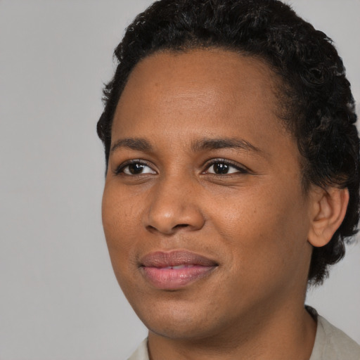 Joyful black young-adult female with short  brown hair and brown eyes