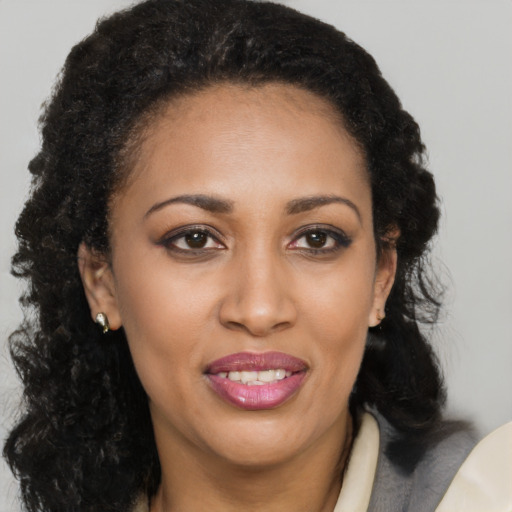 Joyful black young-adult female with long  brown hair and brown eyes