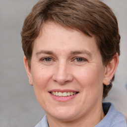 Joyful white adult female with medium  brown hair and grey eyes