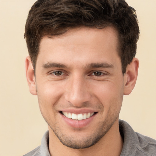 Joyful white young-adult male with short  brown hair and brown eyes