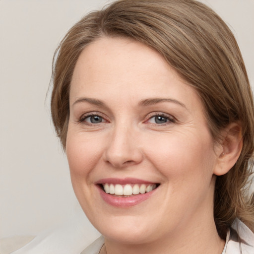 Joyful white young-adult female with medium  brown hair and green eyes