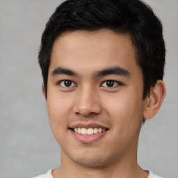 Joyful latino young-adult male with short  brown hair and brown eyes