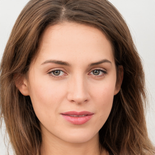 Joyful white young-adult female with long  brown hair and green eyes