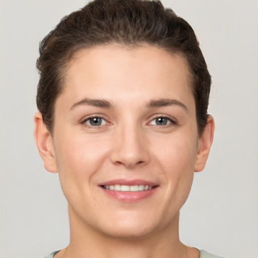 Joyful white young-adult female with short  brown hair and grey eyes