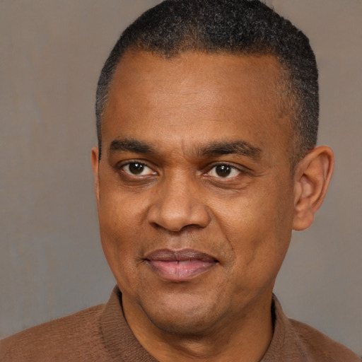 Joyful black adult male with short  black hair and brown eyes