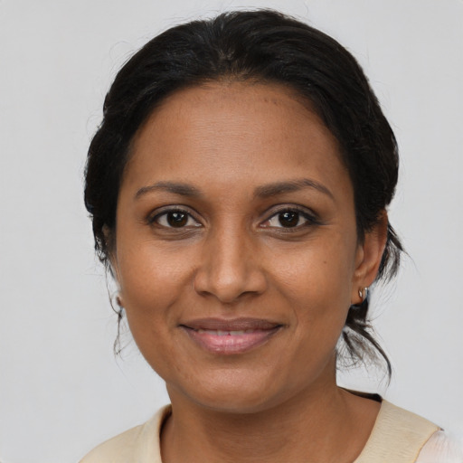 Joyful black adult female with medium  brown hair and brown eyes