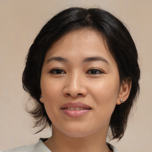 Joyful asian young-adult female with medium  brown hair and brown eyes