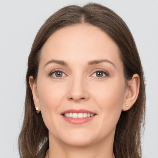 Joyful white young-adult female with long  brown hair and grey eyes