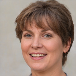 Joyful white adult female with medium  brown hair and blue eyes