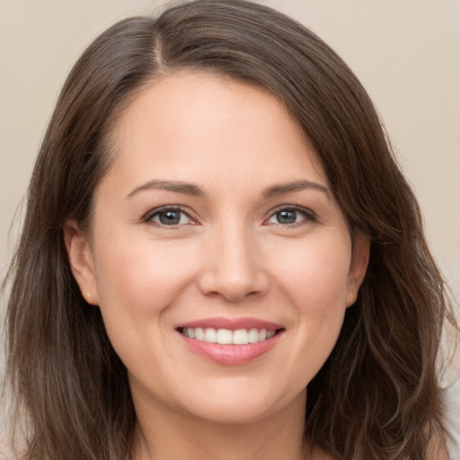 Joyful white young-adult female with long  brown hair and brown eyes