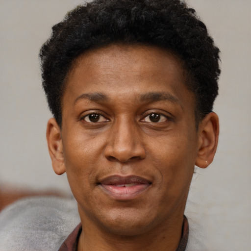 Joyful black adult male with short  brown hair and brown eyes