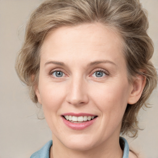 Joyful white adult female with medium  brown hair and blue eyes