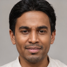 Joyful black young-adult male with short  black hair and brown eyes