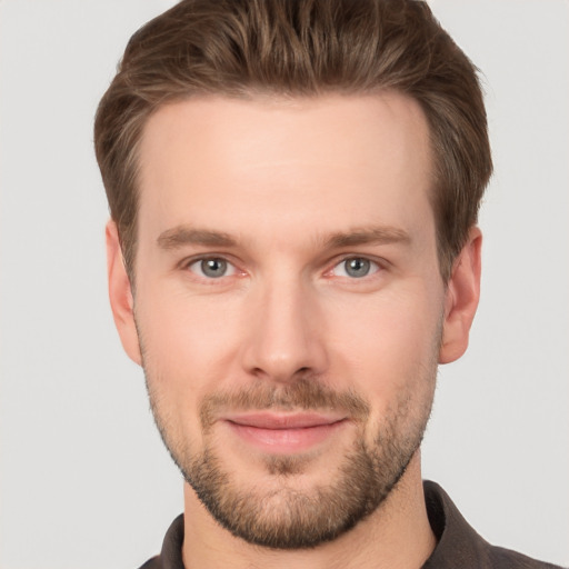 Joyful white young-adult male with short  brown hair and grey eyes