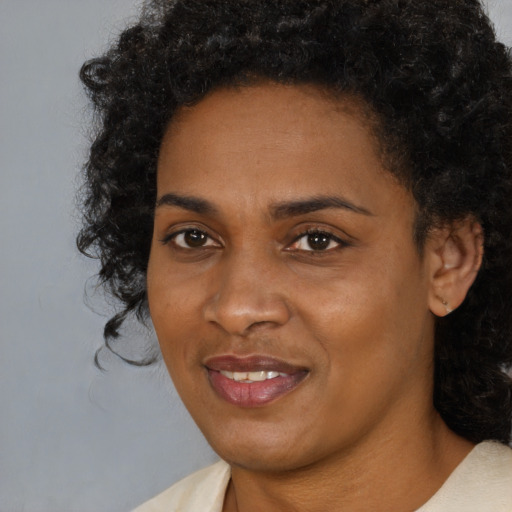 Joyful black young-adult female with medium  black hair and brown eyes