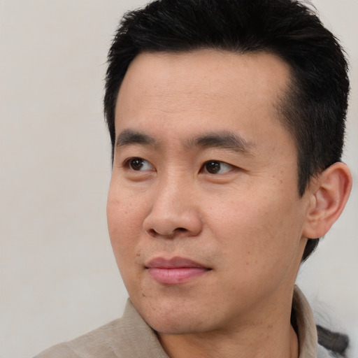 Joyful asian young-adult male with short  black hair and brown eyes