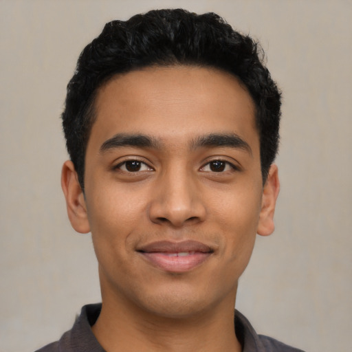 Joyful latino young-adult male with short  black hair and brown eyes