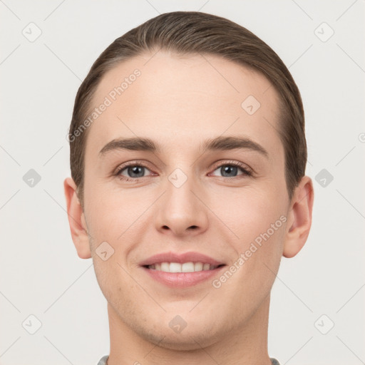 Joyful white young-adult male with short  brown hair and grey eyes