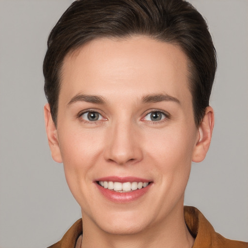 Joyful white young-adult female with short  brown hair and grey eyes