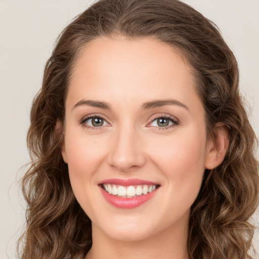 Joyful white young-adult female with long  brown hair and green eyes