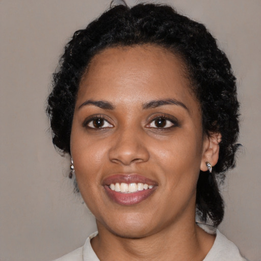 Joyful black young-adult female with medium  black hair and brown eyes