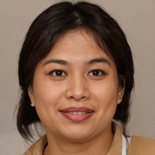 Joyful latino adult female with medium  brown hair and brown eyes
