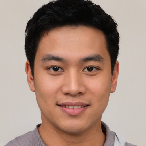 Joyful asian young-adult male with short  black hair and brown eyes