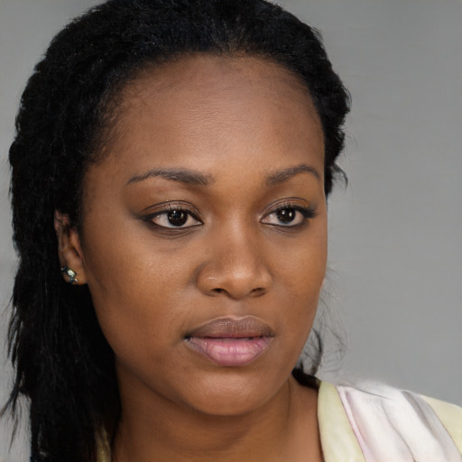 Joyful black young-adult female with long  black hair and brown eyes