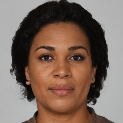 Joyful latino adult female with medium  brown hair and brown eyes