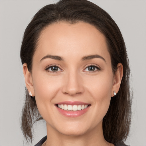 Joyful white young-adult female with medium  brown hair and brown eyes