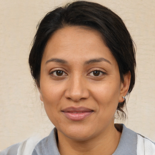Joyful latino adult female with medium  brown hair and brown eyes