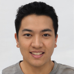 Joyful asian young-adult male with short  black hair and brown eyes