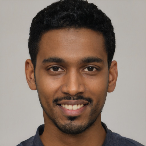 Joyful black young-adult male with short  black hair and brown eyes