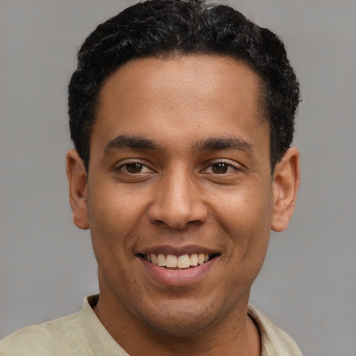 Joyful latino young-adult male with short  black hair and brown eyes