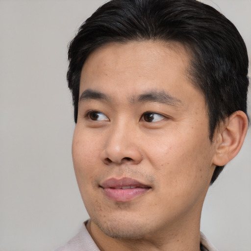 Joyful asian young-adult male with short  brown hair and brown eyes