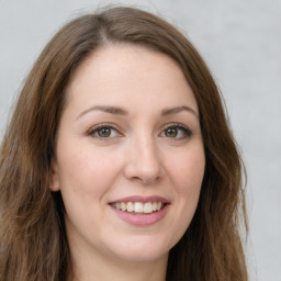 Joyful white young-adult female with long  brown hair and green eyes