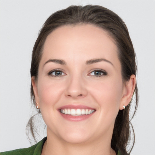 Joyful white young-adult female with medium  brown hair and grey eyes