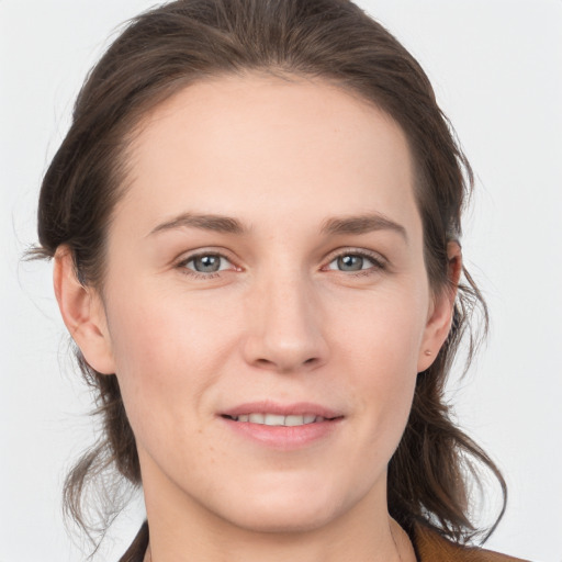 Joyful white young-adult female with medium  brown hair and grey eyes